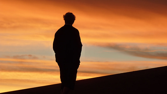 silhouette of person standing on hill during daytime thumbnail