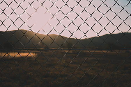 shallow focus photography of cyclone fence during daytime thumbnail