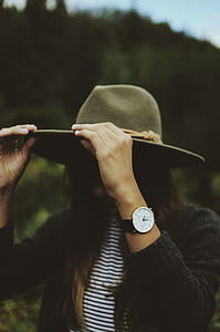 tilt shift lens photography of woman holding her gray suede hat thumbnail
