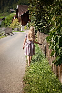 girl in dress standing on dress grass beside pathway thumbnail