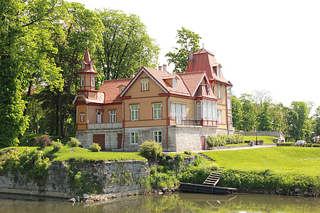 beige painted house near body of water during daytime thumbnail