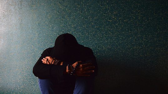 person kneeling beside green wall thumbnail