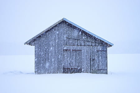 gray house surrounded by snow during winter thumbnail
