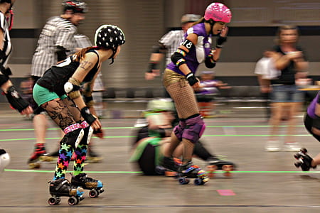 woman in pink helmet skating beside woman in green shorts thumbnail