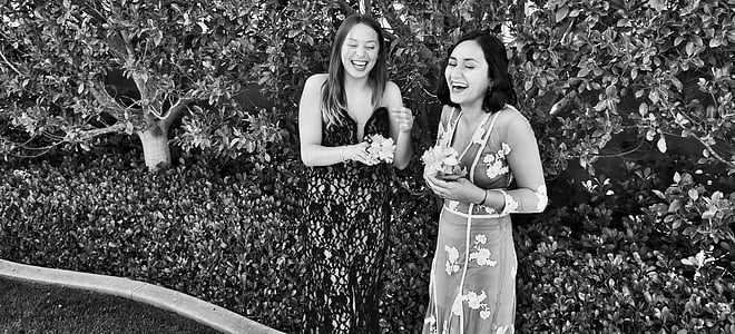 two women laughing in front of bush thumbnail
