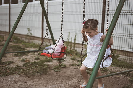 girl sitting on red steel swing thumbnail