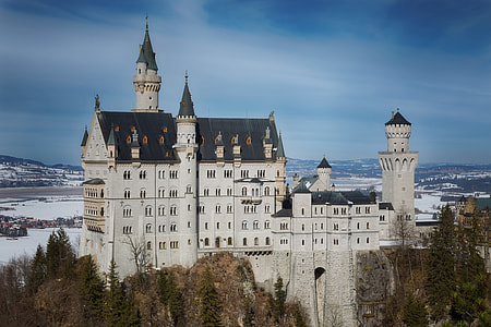 white and black concrete castle near trees during daytime thumbnail