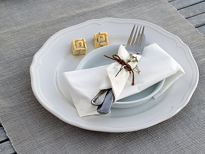 round white plate with fork and bread knife on gray placemat thumbnail