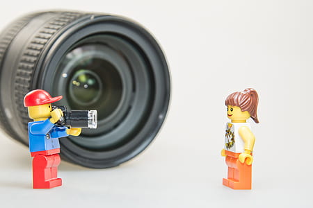 two male and female LEGO minifigures in front black camera lens thumbnail