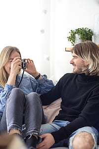 smiling woman taking photo of smiling man sitting beside her thumbnail