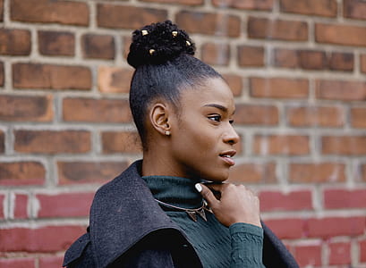 woman wearing turtleneck sweatshirt in front of brick wall thumbnail