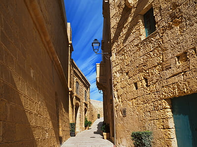 gray pathway between brown buildings thumbnail