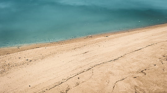 body of water beside brown sand thumbnail