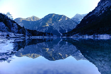 reflection of black mountain on body of water thumbnail