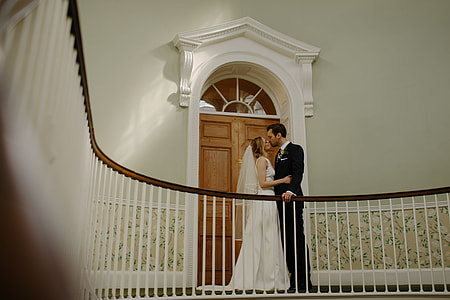 woman in white wedding dress and man black suit kissing together thumbnail