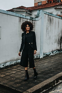 woman standing on sidewalk beside wall outdoors thumbnail