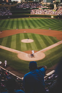 man watching outside baseball field during daytime selective focal photo thumbnail