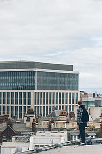 man looking at white concrete building thumbnail