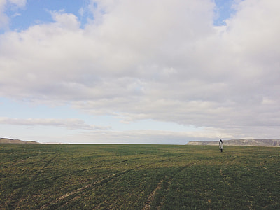 woman in white long coat standing on field thumbnail