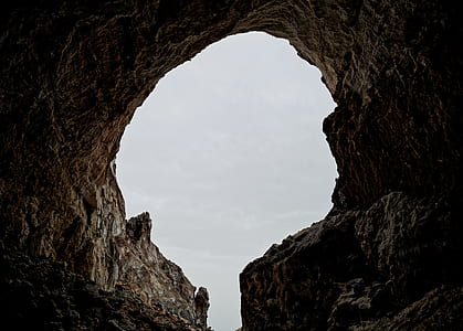 landscape photography of cave under gray sky thumbnail