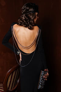woman wearing black long-sleeved dress holding glitter wallet thumbnail