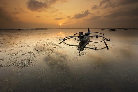 Brown Canoe Docked on Sea thumbnail