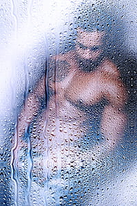 topless man viewed on glass with water droplets thumbnail