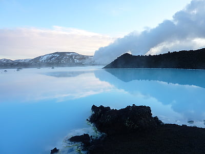 blue steaming lake near snowy mountain under blue sky thumbnail