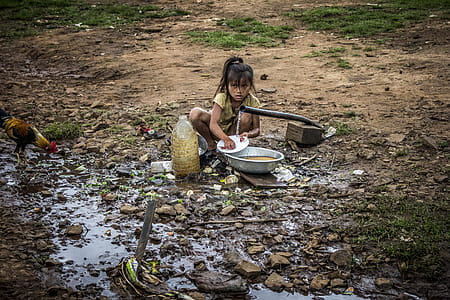 Girl Washing Dishes Sitting Near Plastic Bottle thumbnail