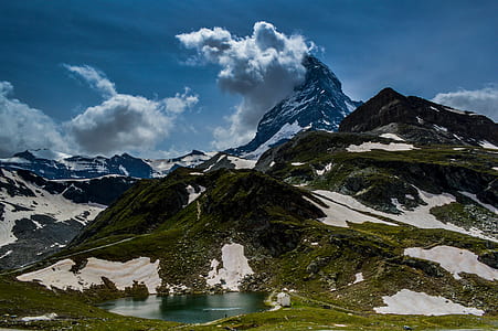 lake beside mountain during daytime thumbnail