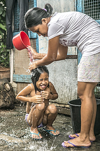 woman pouring water on child thumbnail