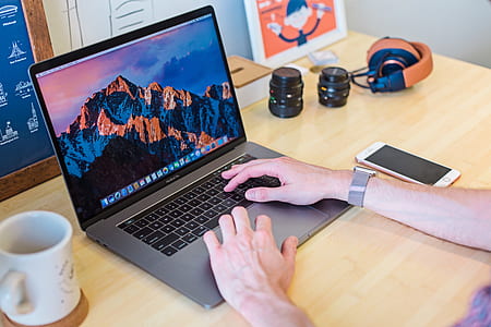 person wearing silver Apple Watch using MacBook Pro thumbnail