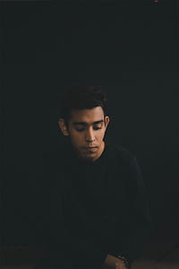 man sitting on chair while looking down thumbnail
