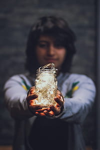selective focus photo of person holding jar filled with string lights thumbnail