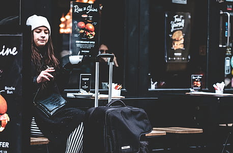 woman sitting in front of black travel luggage thumbnail