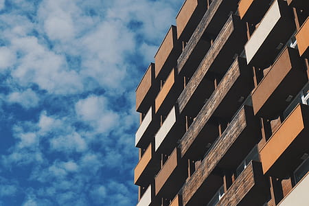 brown concrete building under cloudy sky thumbnail