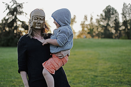 woman wearing mask carrying boy thumbnail