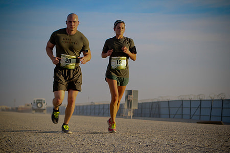 man and woman in green shirt and shorts running during daytime thumbnail