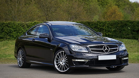 black Mercedes-Benz coupe on asphalt road near bushes thumbnail