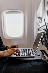 Unrecognizable man with notebook sitting inside an airplane thumbnail