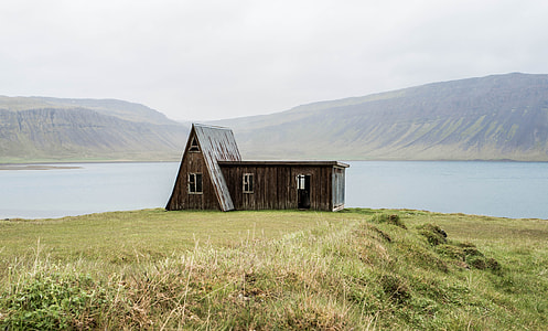 brown and gray wooden house on green grass field during day time thumbnail