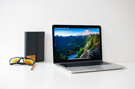 MacBook Pro beside black framed sunglasses thumbnail