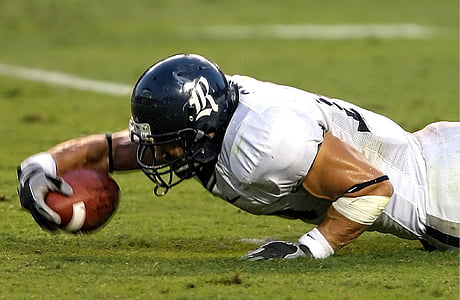 man holding football on the ground thumbnail
