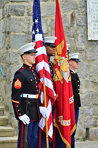 three soldier standing while holding flags at daytime thumbnail