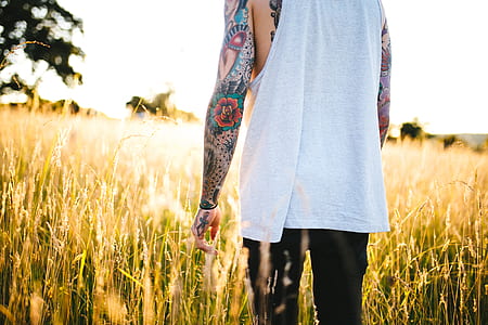person standing on green and brown grass field during daytime photo thumbnail
