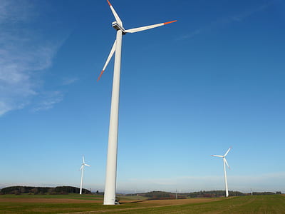 three wind turbines on green grass field thumbnail
