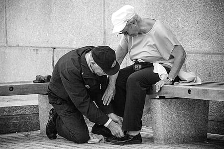 man kneeling on floor in front of woman sitting on concrete bench thumbnail