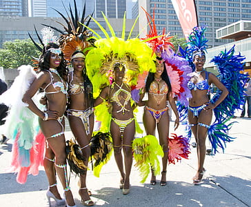 five women wearing costume standing beside building thumbnail