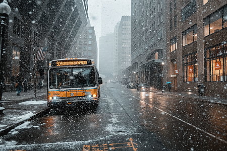 yellow bus pars near sidewalk during snow weather thumbnail