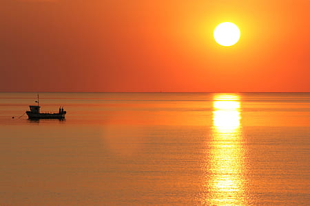 silhouette of boat on body of water thumbnail